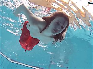 crimson clothed teenage swimming with her eyes opened