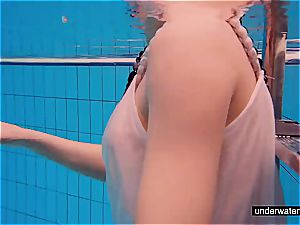 ginger-haired stunner swimming naked in the pool