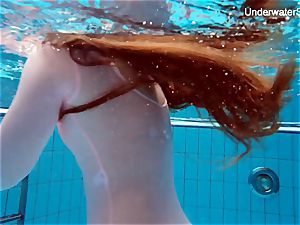 red-haired Simonna displaying her assets underwater